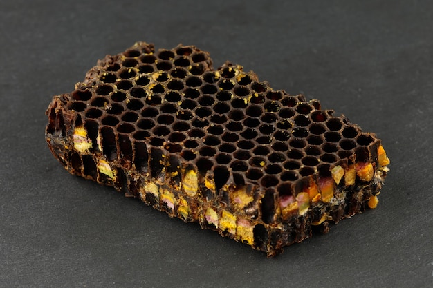 Bee pollen in honeycomb Bee bread isolated on a black background