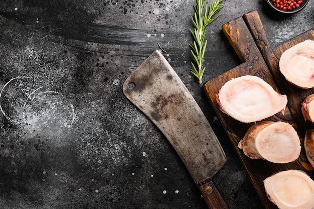 Beef Bone Marrow set, on black dark stone table background, top view flat lay, with copy space for text