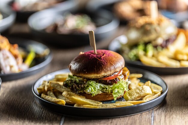 Beef burger with fries and draft beer on a pub or restaurant plate