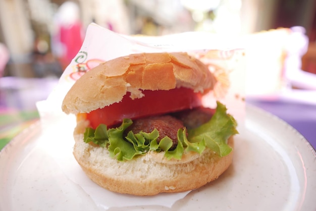 beef burger with a paper on a plate outdoor cafe eating food at street concept