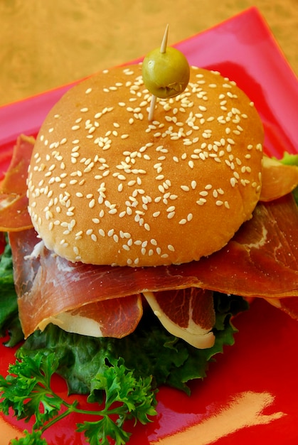 Beef burger with serrano ham on a wooden table close up view fast food food