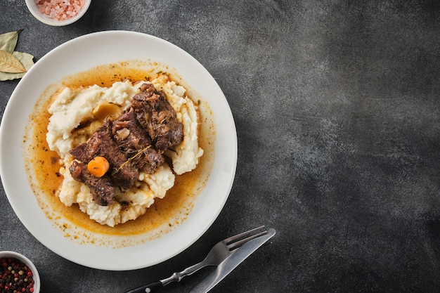 Beef cheeks with mashed potatoes on white plate