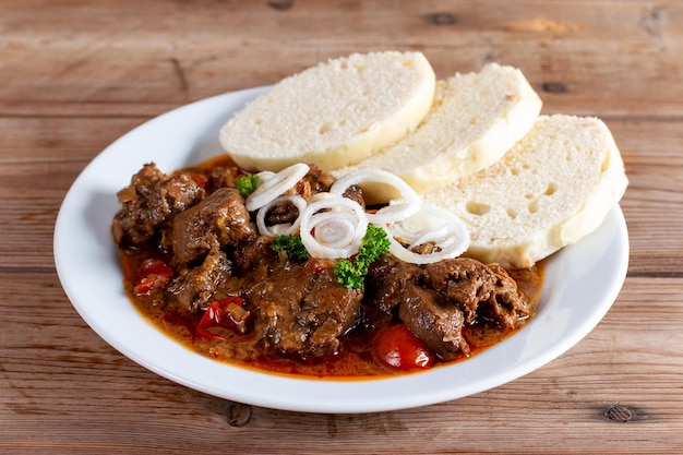 Beef goulash and dumplings knedliky on table from Czech Republic