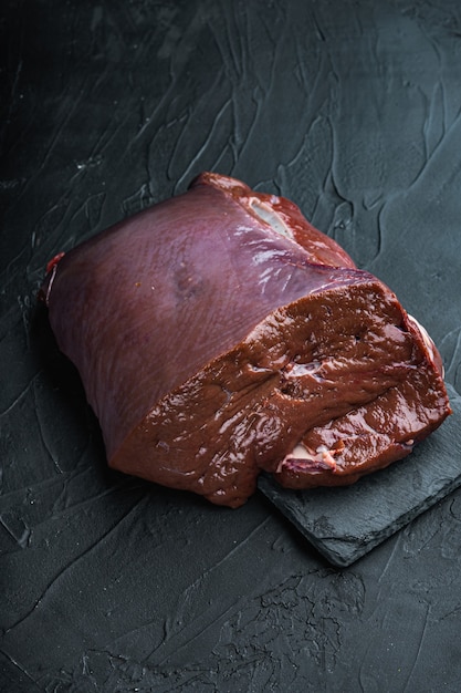 Beef liver on black background.