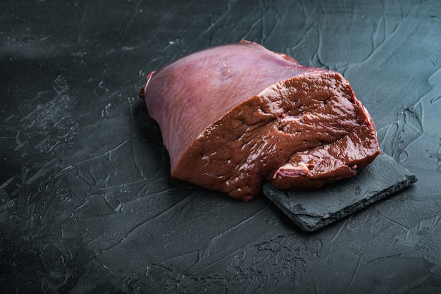 Beef liver on black with copy space