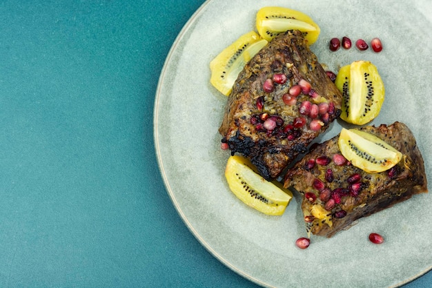 Beef meat baked with kiwi and pomegranate