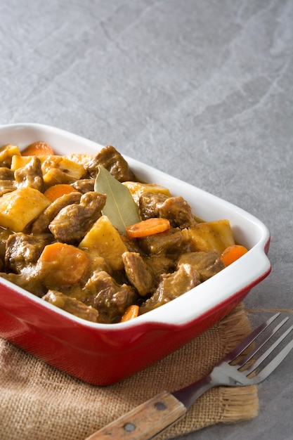 Beef meat stewed with potatoes, carrots and spices in ceramic pot