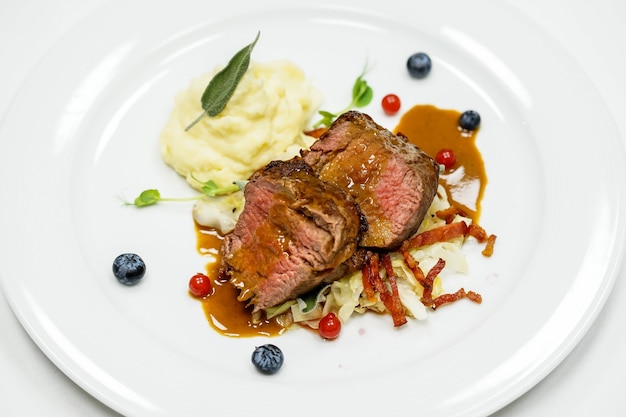 Beef meat with mashed potatoes and sauce on plate