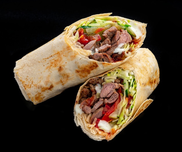 Beef shawarma on a dark background Shawarma with beef in pita bread