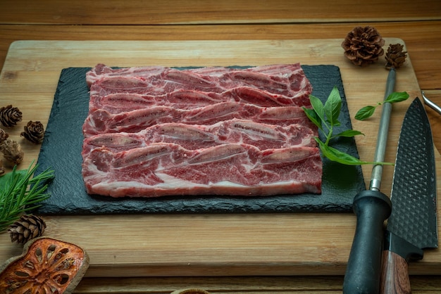 Beef Short Ribs Sliced Bonein on wooden backgroundCross Cut Short Ribs beef on black plate