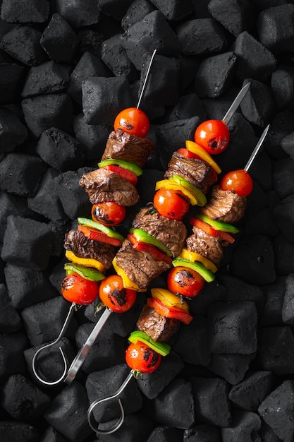 Beef skewers being grilled on a embers top view