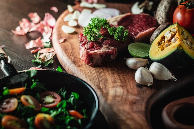 ิbeef steak on a cutting board with a knife and ingredients