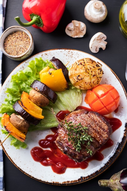 Beef steak  grilled vegetables on a plate. Top view.