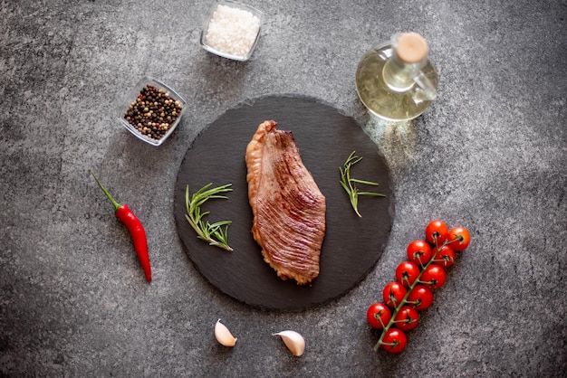 Photo beef steak herbs and spices on a stone background