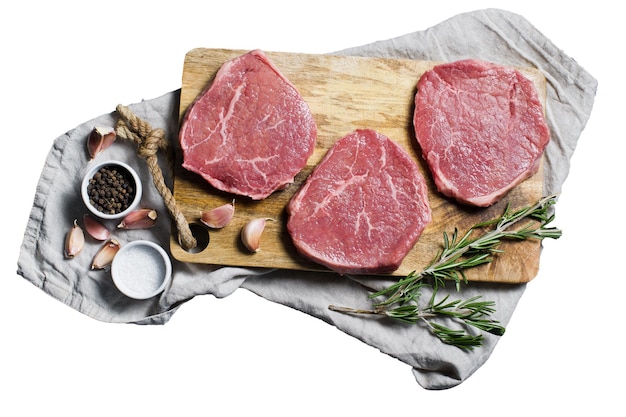 Beef steak tenderloin on a wooden chopping Board garlic and a sprig of rosemary Isolated on white background