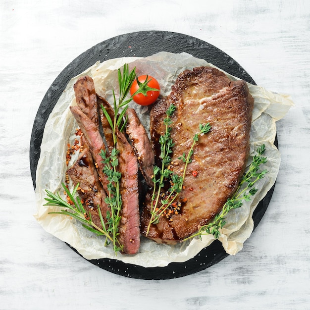 Photo beef steak veal meat with spices and vegetables on a white wooden background flat lay top view