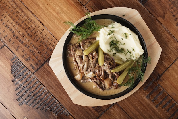 Beef stroganoff with mushed potatoes and pickled cucumbers