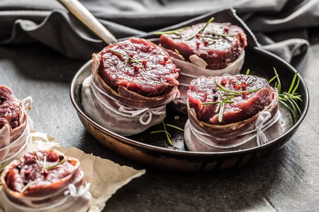 Beef tenderloin steak wrapped in bacon stored into the pan.