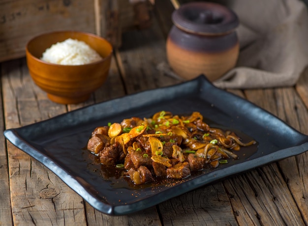 BEEF TEPPANYAKI served in a dish isolated on wooden background side view of Teppanyaki