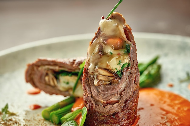 Beef wellington with cheese inside asparagus and sauce Closeup Selective focus