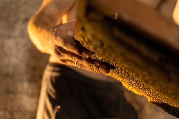 A beekeeper holds a frame of honey that drips