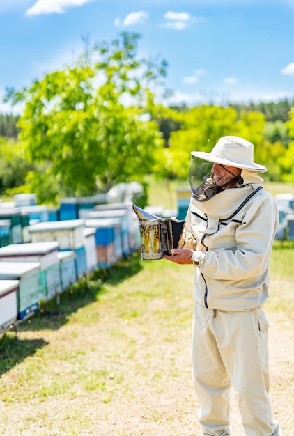 Beekeeper man in protective costume Farmer in bee costume workiing with beehives