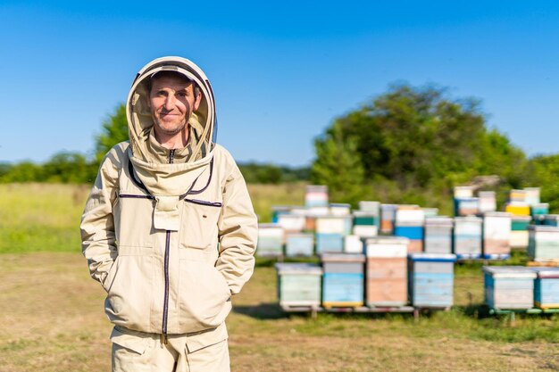 Beekeeping specialist in protective suit Beehive farming field