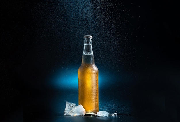 Beer bottle splashing drops on a black and blue background a beer bottle with splashing drops with i