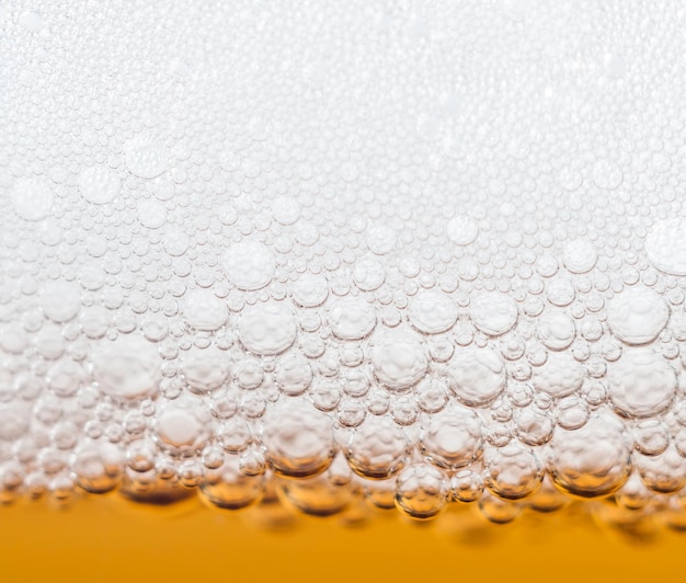 Beer bubbles in a glass of fresh amber beer