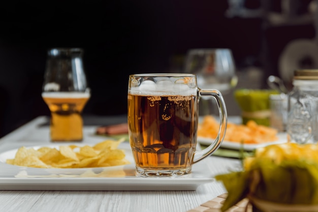 Beer and chips on a large white table