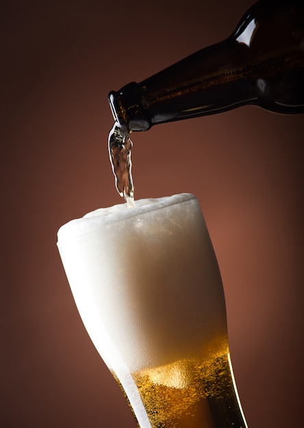 Beer glass and bottle on a brown