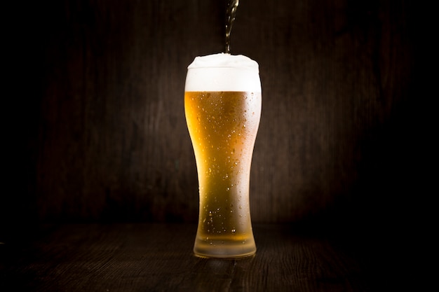 Beer glass in front of black background