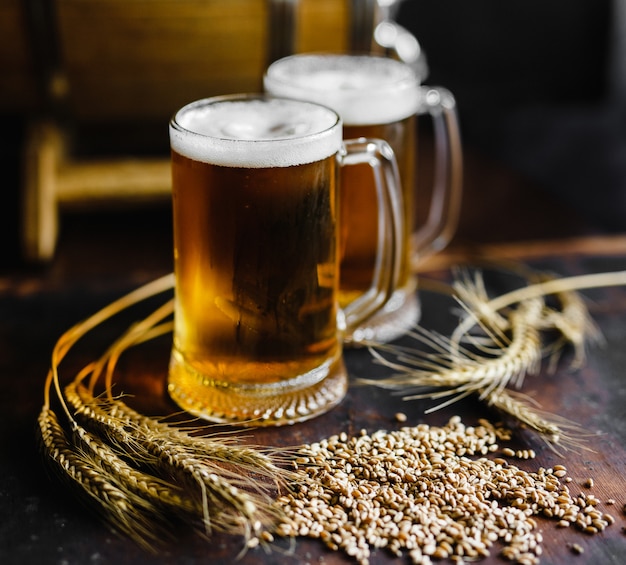 Beer glasses and wheat spice on an old rustic  wood table on black background