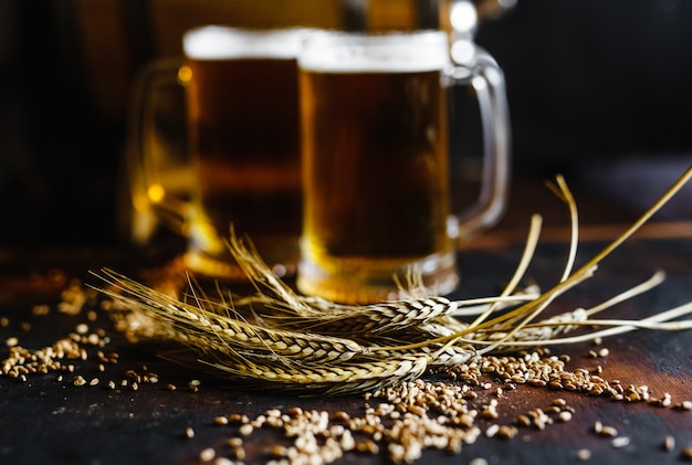 Beer glasses and wheat spice on an old rustic  wood table on black background