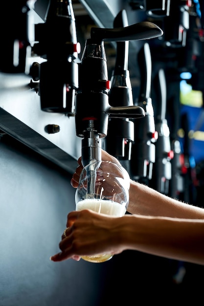 Beer is poured from the tap into the glass Closeup selective focus Noise added in postproduction