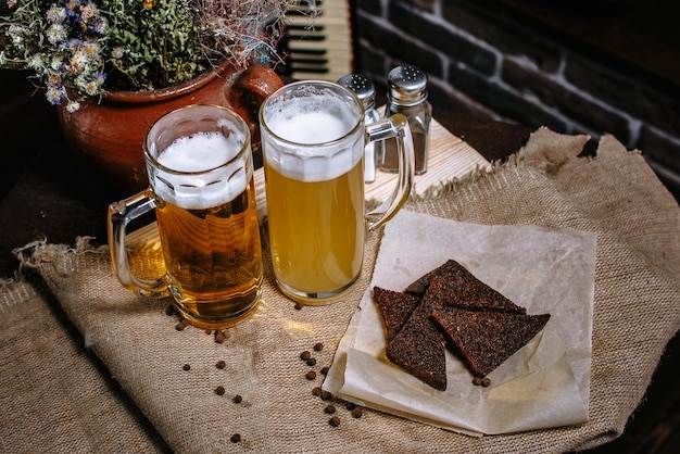 Beer in a large mug standing on the table Fried toast from black bread in a plate