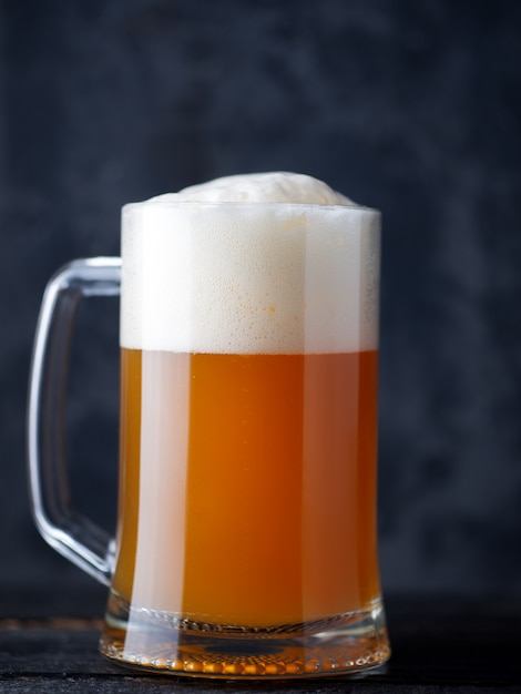 Beer mug unfiltered wheat beer close-up with a large foam cap