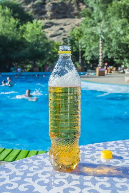 Beer in a plastic bottle on the background of the pool Pleasant rest Relaxation of the soul and body