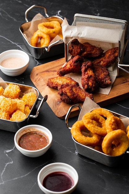 The beer plate with spicy chicken wings calamari rings fries onion rings cheese balls potatoes breaded