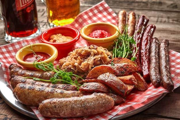 Beer set of grilled sausages with stewed cabbage potato wedges and sauces