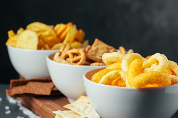 Beer snacks on stone table. Various crackers, potato chips. Top view