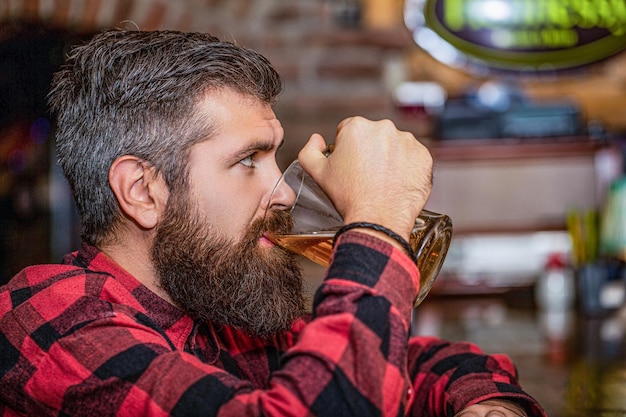 Beer time Man drinks beers at the bar counter People lifestyle recreation Man with beer Bearded hipster holds glass of beer Beer pub Stylish guy at cafe pub