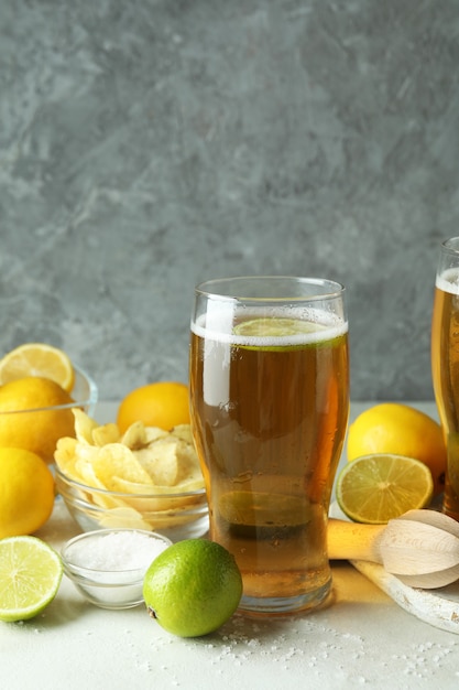 Beer with citrus against gray textured background