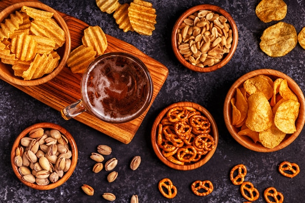 Beer with snacks on stone background