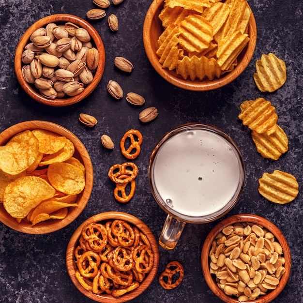 Beer with snacks on stone background