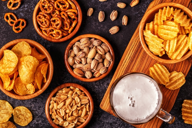 Beer with snacks on stone background