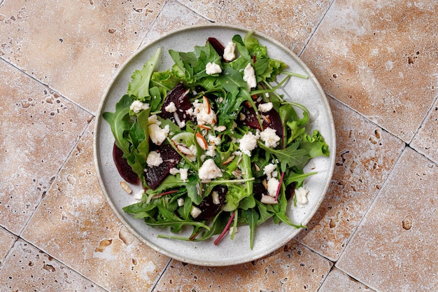 Beet salad with mix lettuce leaves salad with feta cheese nuts on plate Fresh green snack Keto diet