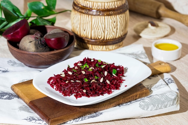 Beet salad with sunflower oil parsley and sunflower seeds in a plate on a cutting board