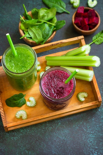 Beet smoothie and Green smoothie celery and spinach on a stone background Top view Copy space