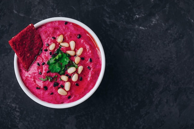 Beetroot Beet Hummus with crispbread Healthy vegan dip on dark stone background copy space